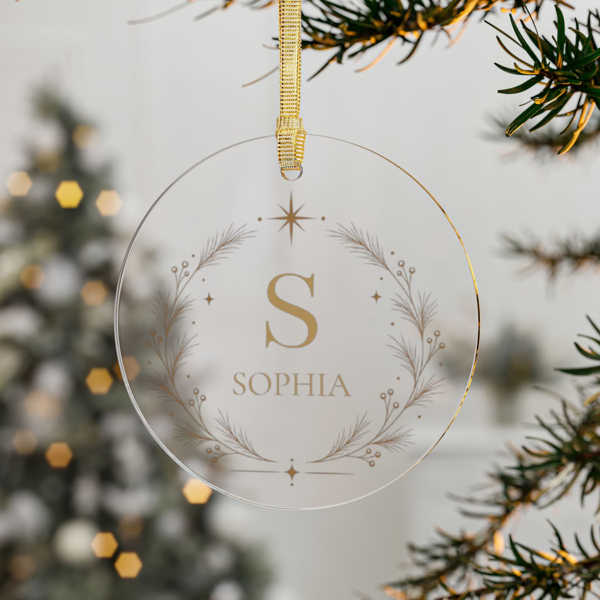 Clear acrylic monogram name ornament hanging on a Christmas tree