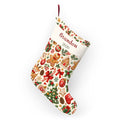 Baby's first Christmas stocking hanging from its loop, full view on white