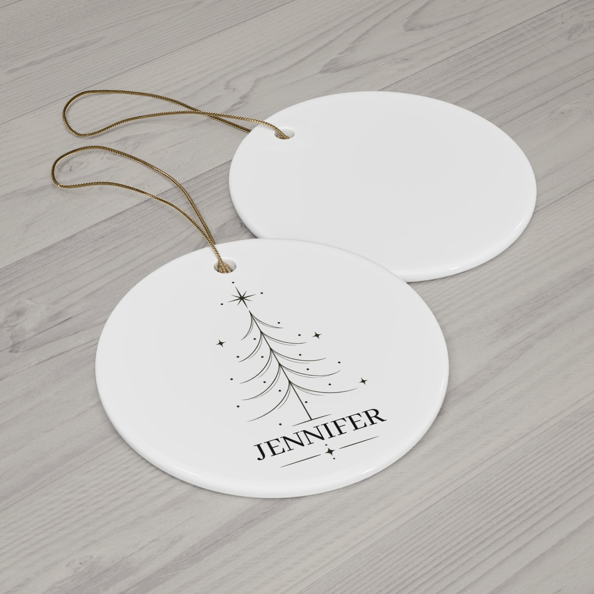 Round Christmas tree name ornament with its blank back side on a wooden table