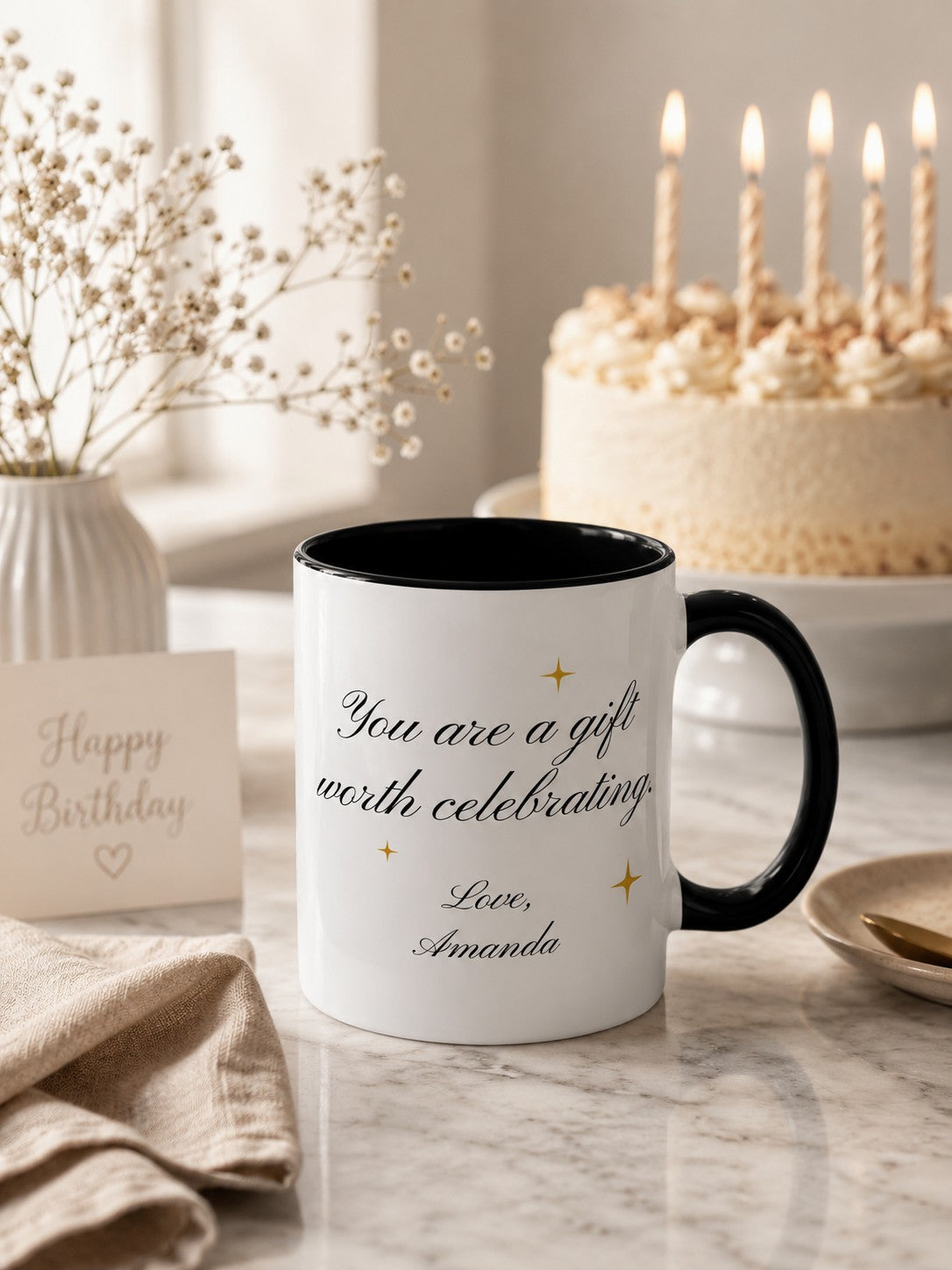 Personalized birthday mug styled on a marble countertop with birthday cake and lit candles in soft focus