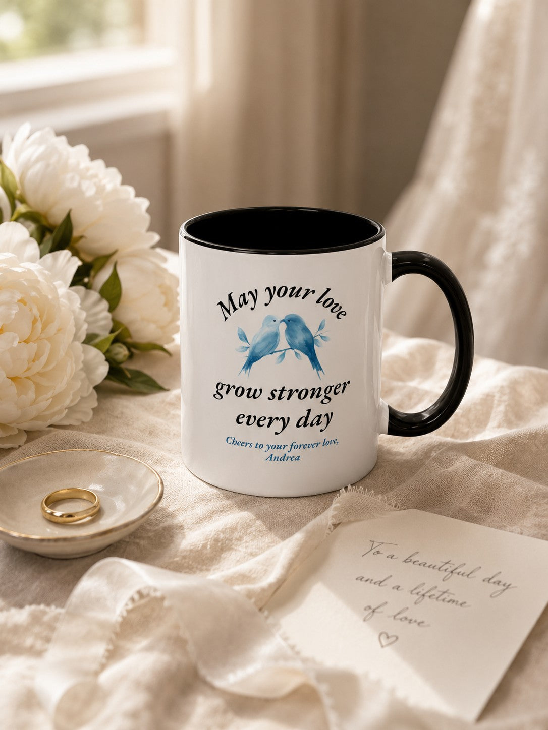 Two personalized couples mugs on a marble surface with a small candle and dried lavender stems for an intimate anniversary celebration